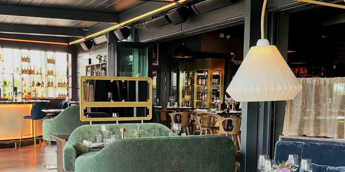 DOX Rooftop Bistro & Cocktailteria in Alingsås with takmonterade Dark Heater from Infracenter ovanförthe gröna soffgruppen.