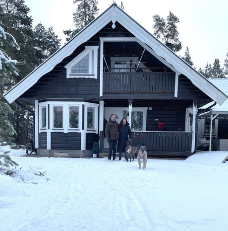 Jessica med sin make och hund framför huset där de installerat infrapaneler från Infracenter och minskat energiförbrukningen.
